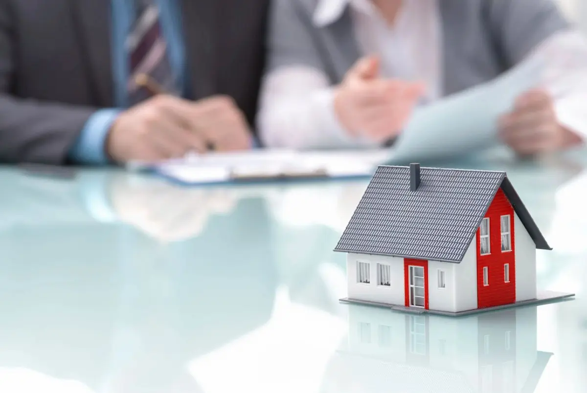 Experienced real estate agent showing house model to client